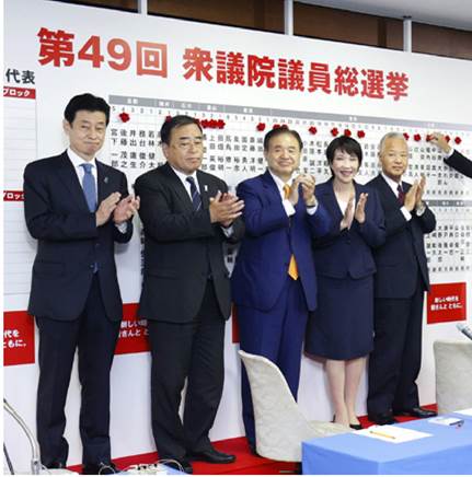 2 0 2 1年1 0月3 1日，日本首相、自民党总裁岸田文雄（左六）在位于东京的自民党总部为众议院选举中的当选人名字贴上红花。（新华社图片）
